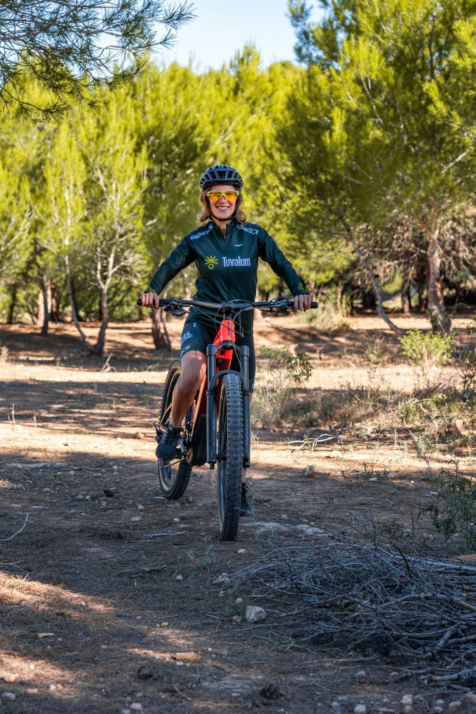 a man riding a bicycle on a dirt path in the woods